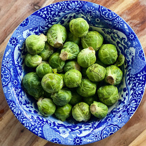 fresh brussell sprouts in a blue and white bowl