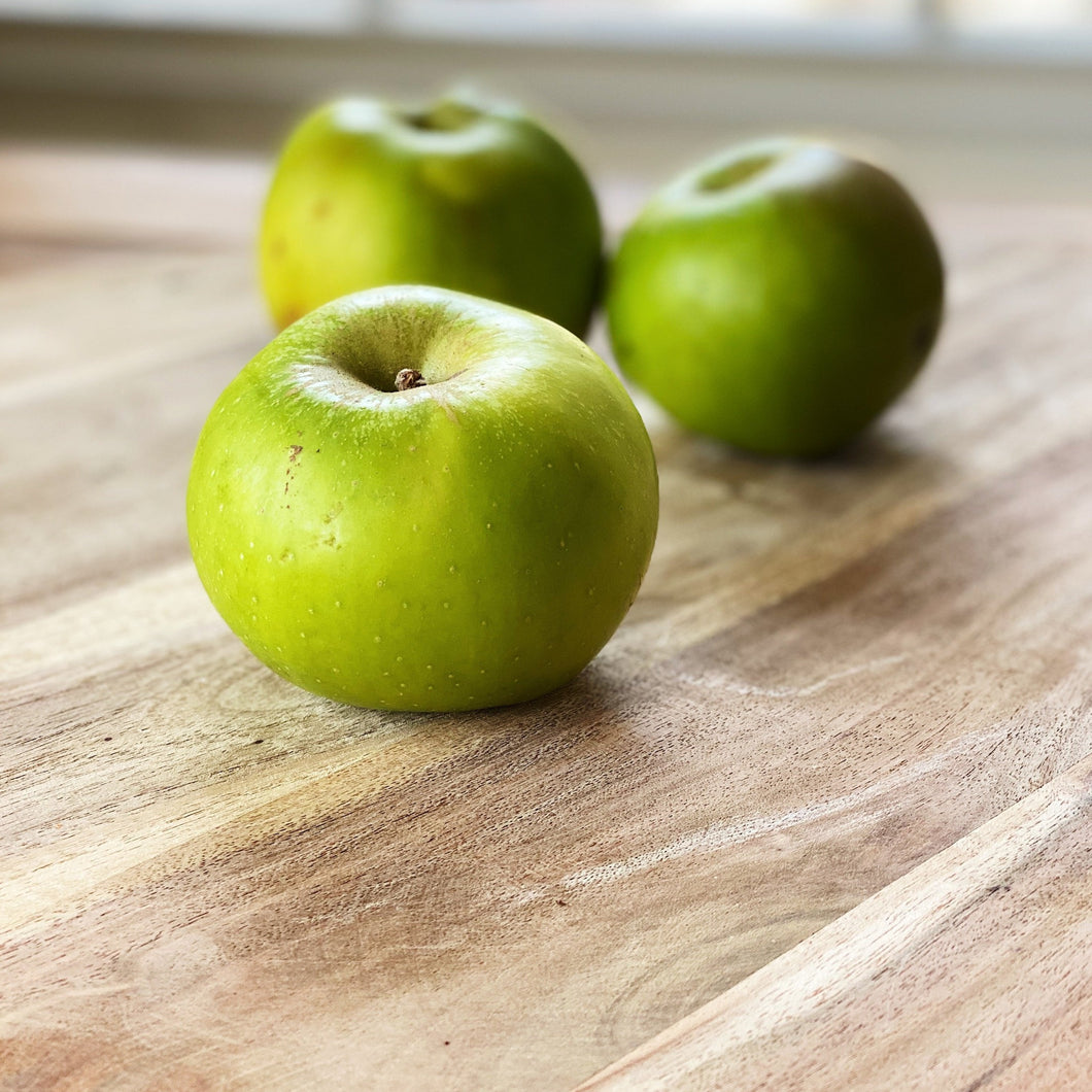 bramley cooking apples on a wooden board