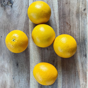 5 small fresh oranges on a wooden board