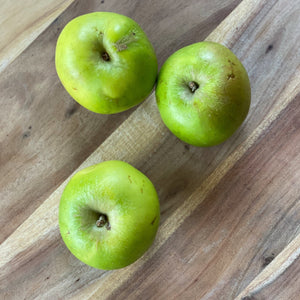 bramley cooking apples on a wooden board